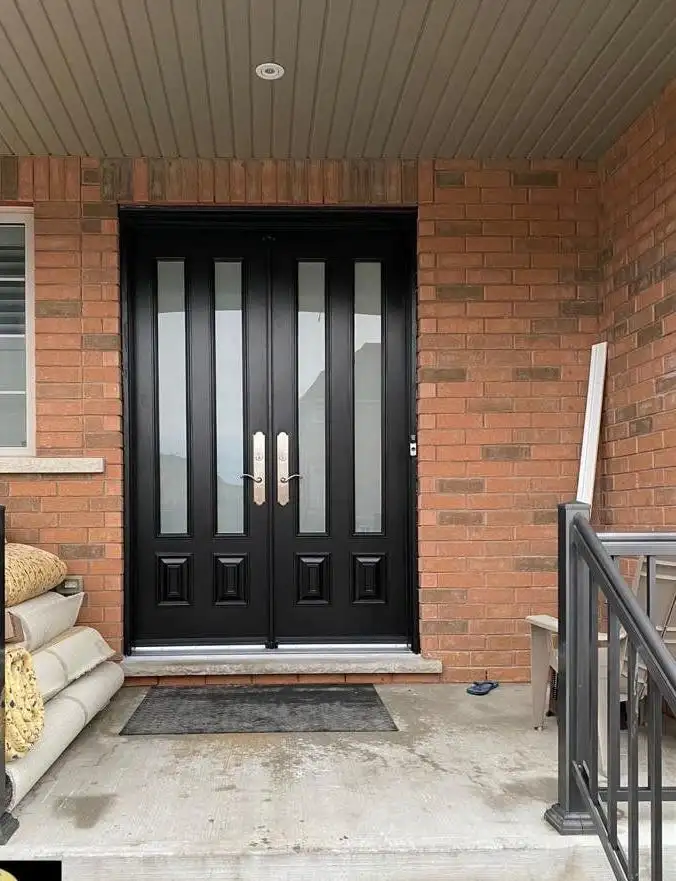 Black double entry door with tall glass lites on a covered porch with black railings