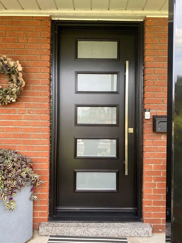 Black entry door with five frosted glass lites and a long pull, in a red brick entrance