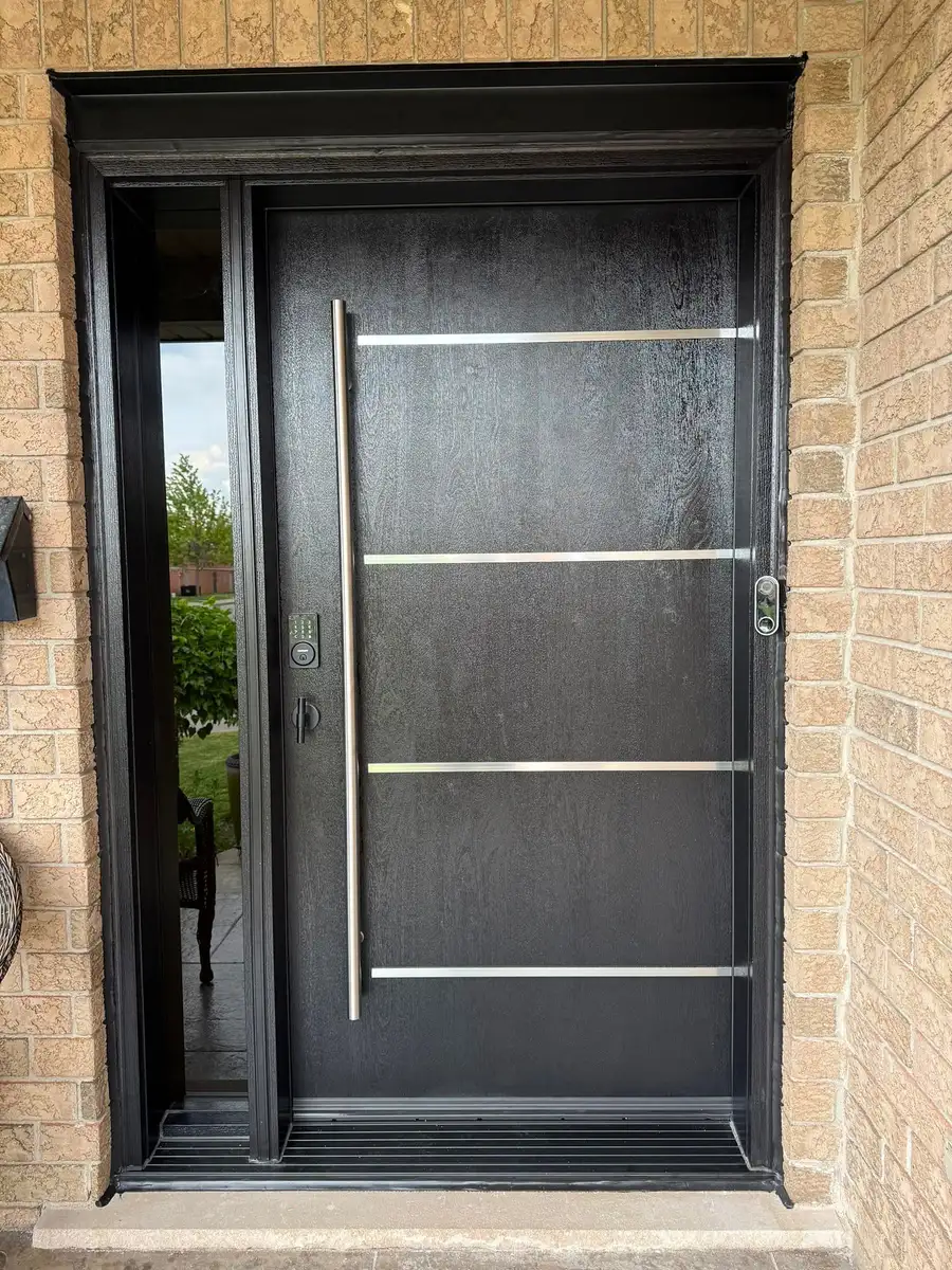 Black woodgrain entry door with a full-height glass sidelite, horizontal stainless bars and a long vertical pull
