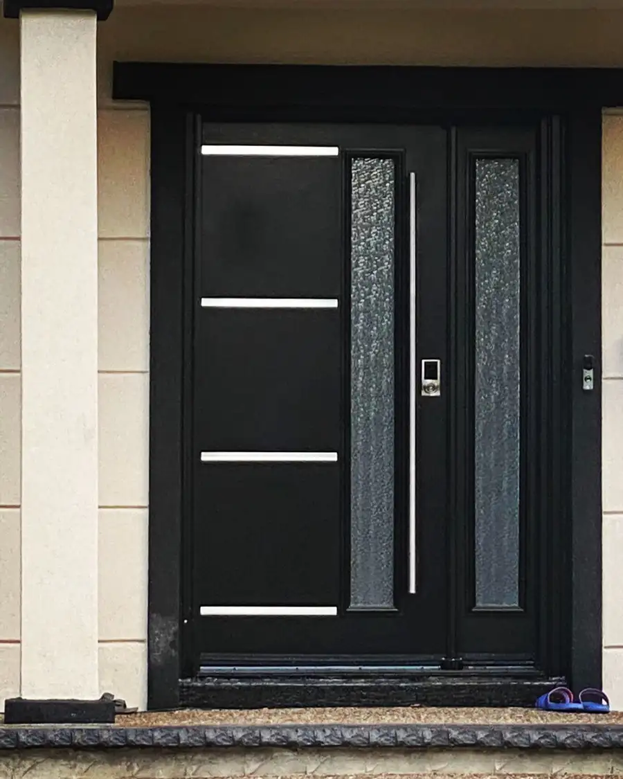 Black entry door with stainless bars, a textured glass insert and a matching textured glass sidelite