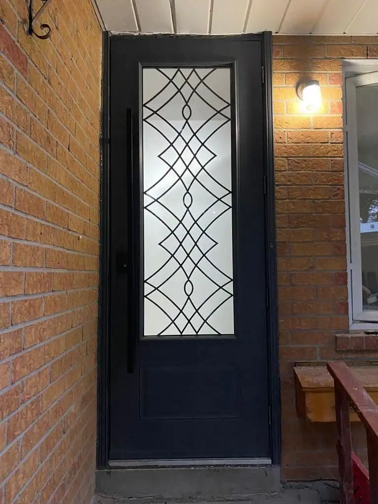 Black entry door with a tall wrought-iron glass insert, in red brick