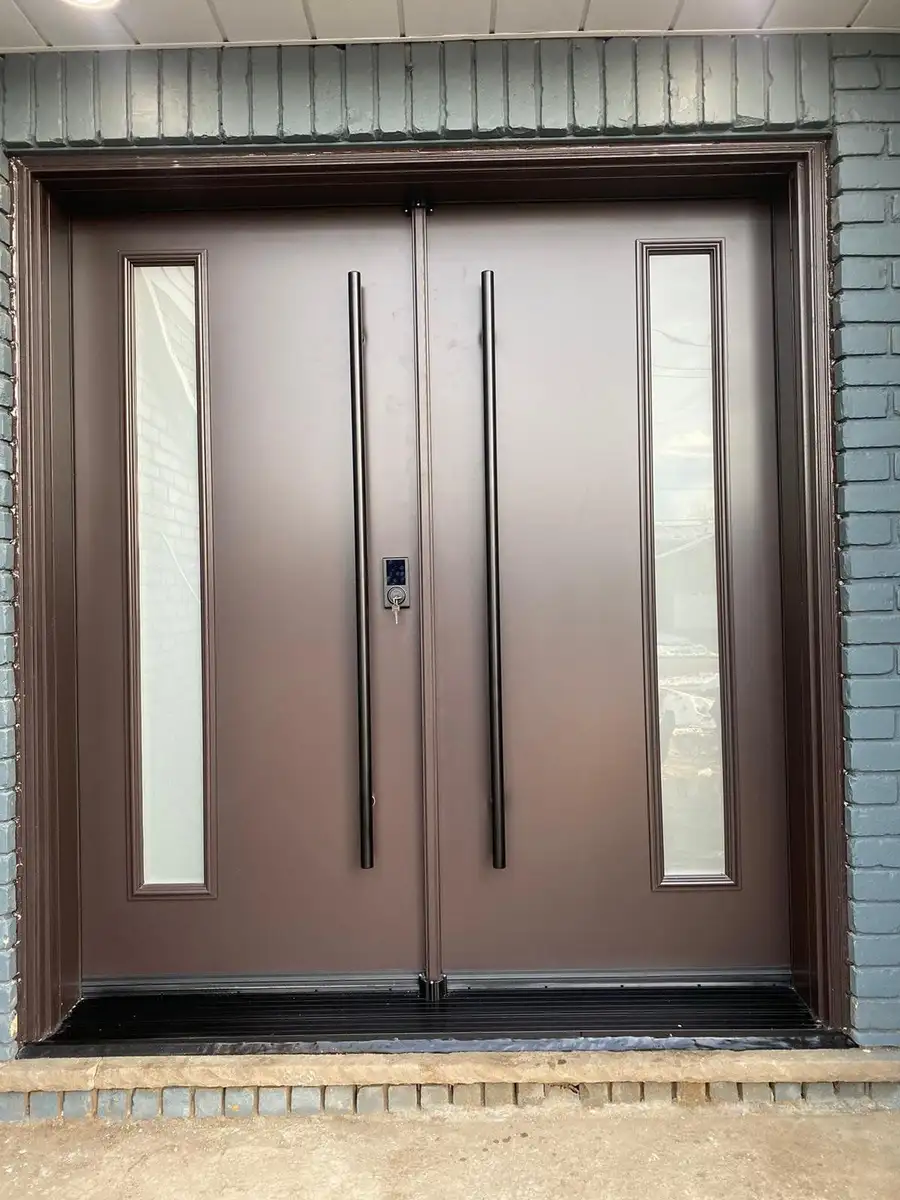 Brown double entry door with long black pulls and frosted sidelites, in a brick entrance