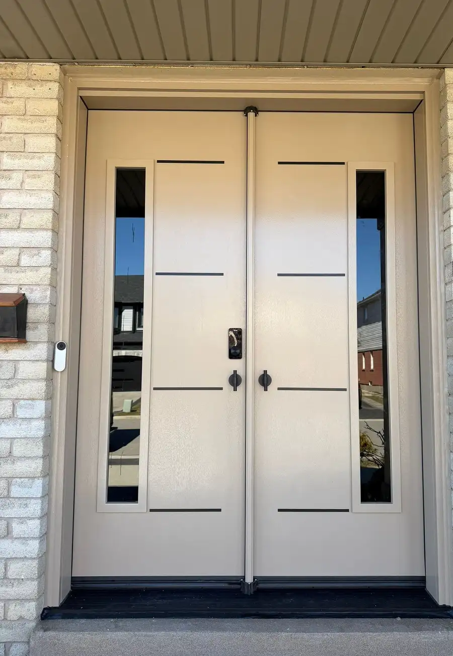 Cream double entry door with black horizontal inlays and narrow glass sidelites, under a white soffit