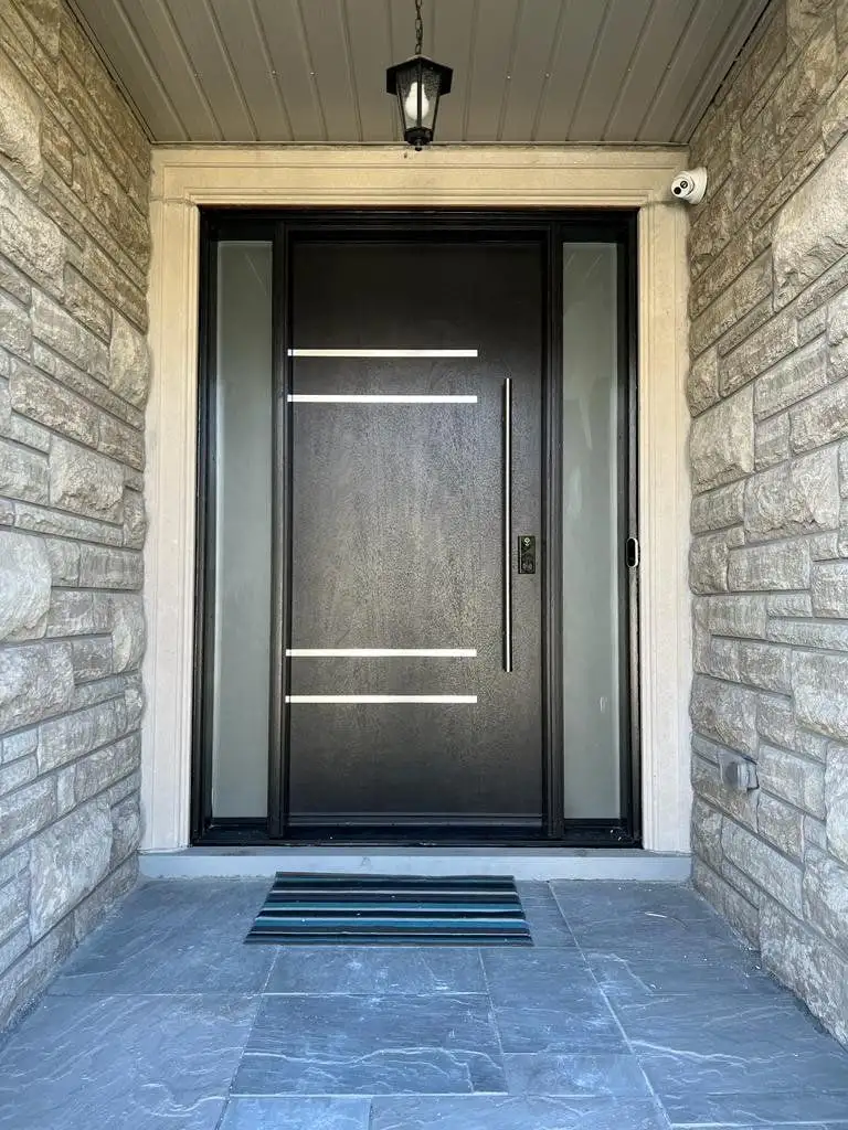 Espresso entry door with horizontal stainless bars and a narrow sidelite, in a stone entrance with a slate step