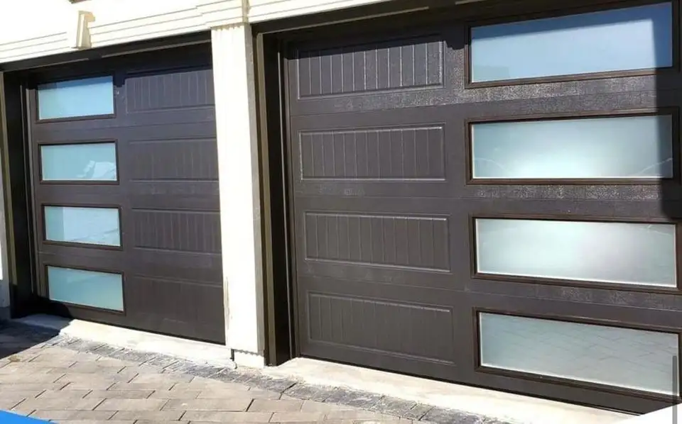 Brown woodgrain garage doors with a column of frosted glass lites, under a white soffit