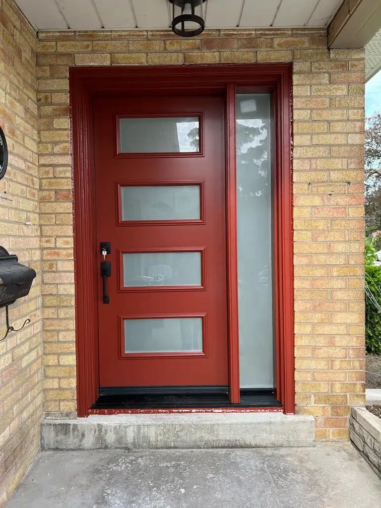 Deep red entry door with five frosted glass lites and a matching sidelite, in buff brick