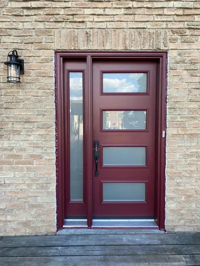 Red entry door with frosted glass lites and a matching sidelite, in buff brick